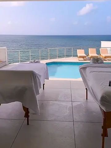 Two massage tables beside an oceanfront villa pool in St. Maarten