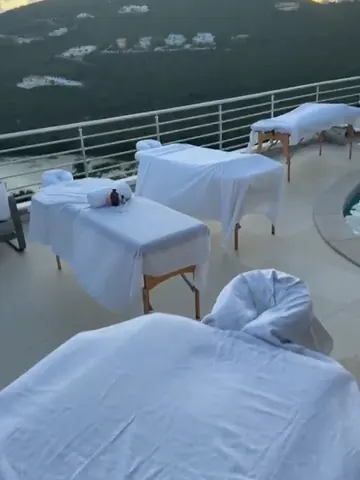 Four massage tables on a hillside villa terrace at sunset in St. Maarten