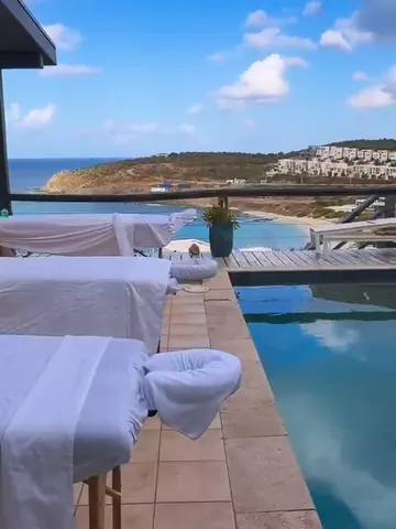 Massage tables lined up along an infinity pool overlooking the bay in St. Maarten