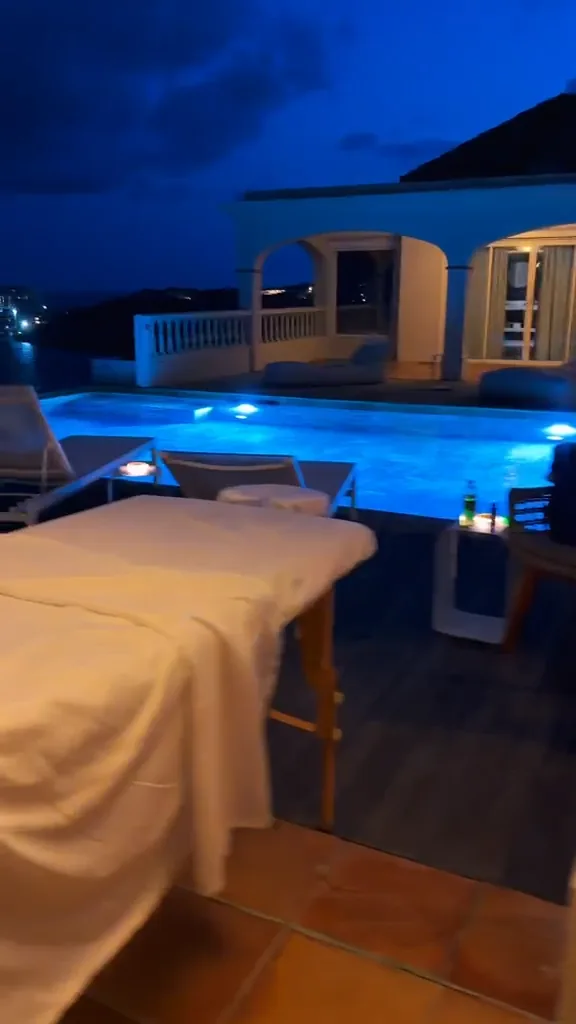 A single massage table set up poolside in the evening, representing a private single wellness session in St Maarten.