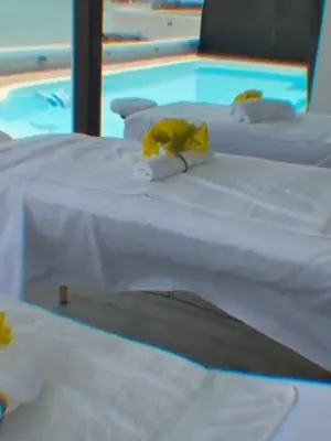 Massage tables with yellow roses and fresh towels set up beside a villa pool in St. Maarten