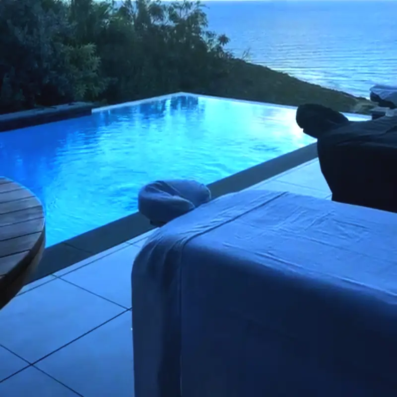 Licensed therapist performing a deep tissue massage on a client at a private villa in St Maarten with ocean views.